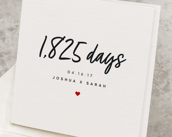 May include: A white card with black text that reads "1,825 days" and "04.16.17 Joshua x Sarah". A small red heart is below the text.