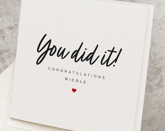 May include: A white card with black text that reads "You did it! Congratulations Nicole" with a small red heart below the text.