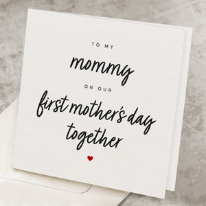May include: A white card with black text that reads "To my mommy on our first mother's day together" with a small red heart at the bottom.
