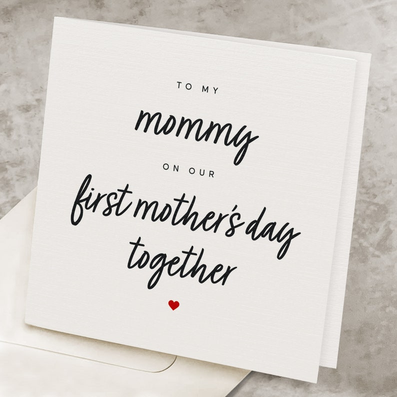 May include: A white card with black text that reads "To my mommy on our first mother's day together" with a small red heart at the bottom.