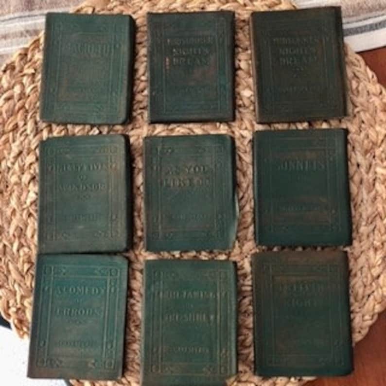 May include: Set of nine small, green leather-bound books with gold lettering on the covers. The titles include "A Midsummer Night's Dream", "The Rivals", "The School for Scandal", "The Rivals", "As You Like It", "Twelfth Night", "The Comedy of Errors", "The Taming of the Shrew", and "The Merchant of Venice".