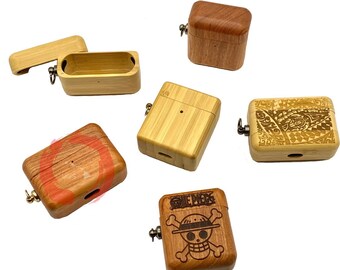 May include: Wooden AirPod cases in various designs. Some cases are plain, while others feature engraved patterns or the "One Piece" logo. The cases are rectangular with a hinged lid and a small metal loop for attachment.