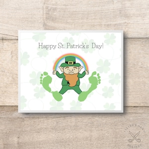 May include: A printable card with a green leprechaun wearing a hat and holding a pot of gold. The leprechaun is standing on two green footprints. The card has a rainbow above the leprechaun and the text "Happy St. Patrick's Day!" at the top.