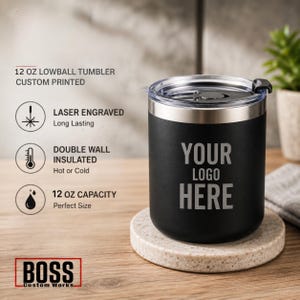May include: A matte black 12 oz lowball tumbler with a clear plastic lid. The tumbler features the laser-engraved text 'YOUR LOGO HERE' on the front. Text on the image includes '12 OZ LOWBALL TUMBLER CUSTOM PRINTED', 'LASER ENGRAVED', 'DOUBLE WALL INSULATED', '12 OZ CAPACITY', and 'BOSS Custom Works'.