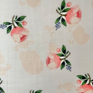 May include: White fabric with a repeating pattern of pink flowers and green leaves. The flowers have a watercolor effect and are surrounded by small blue berries.