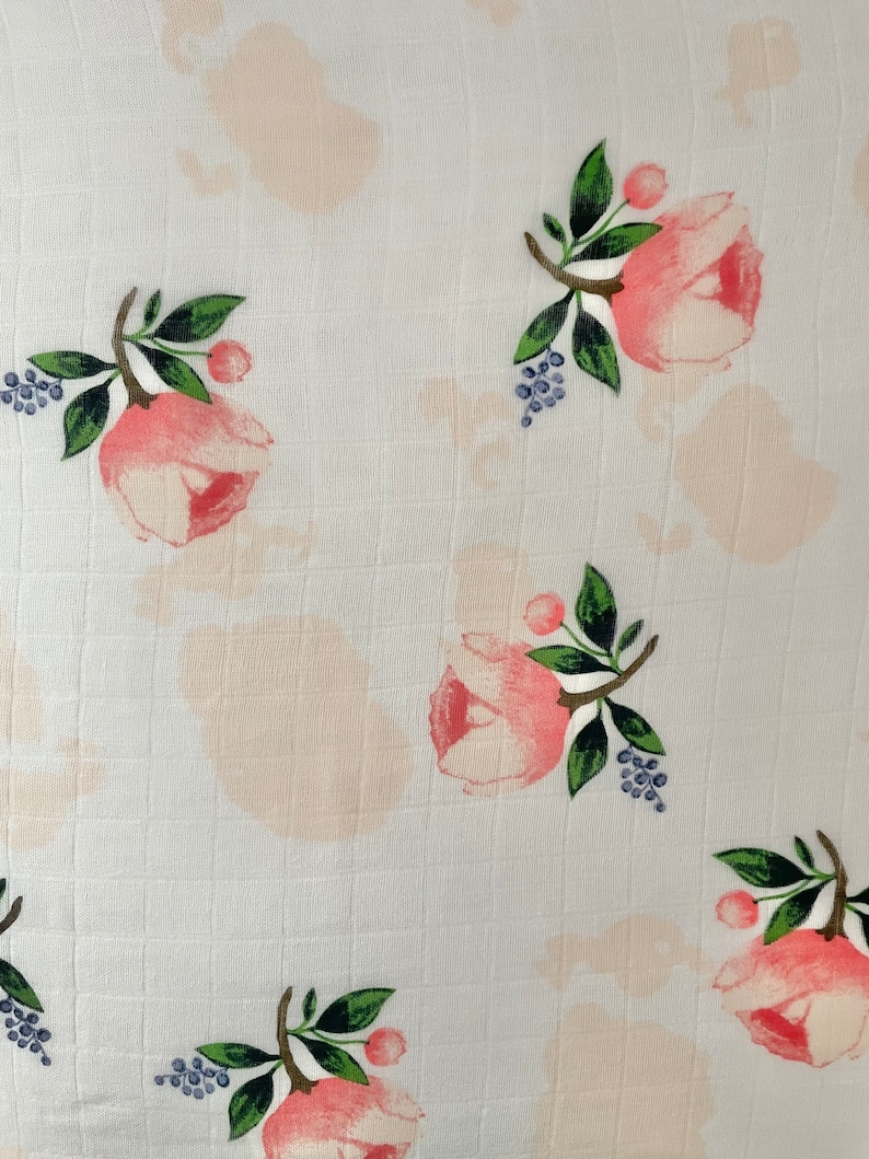 May include: White fabric with a repeating pattern of pink flowers and green leaves. The flowers have a watercolor effect and are surrounded by small blue berries.