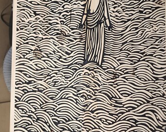 Puede incluir: Una imagen quemada en madera de una persona de pie en un mar de olas. La imagen está en una tabla de madera.