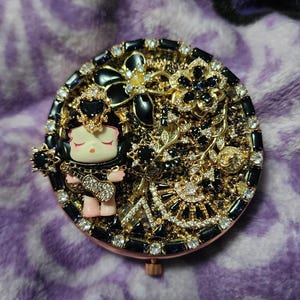 Beautiful Unique Handmade Skullpanda black and gold handheld mirror. Decoden metal charms, perfect as a unique gift for yourself or a friend