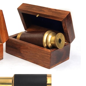 May include: A brass telescope with a black leather grip, displayed in a wooden box with a dark blue velvet lining. The box is made of dark wood. The telescope is also shown separately.
