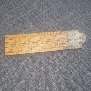 Puede incluir: Una regla plegable de madera vintage, marcada con medidas en pulgadas de 7 a 17. La regla es de color marrón claro con marcas negras y una pieza final de metal. El texto "SOXWOOD RABONE" y "MADE IN ENGLAND" son visibles.