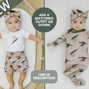 May include: Two baby outfits with a pheasant print. The outfit on the left is a white bodysuit with brown shorts. The outfit on the right is a brown gown with long sleeves. Both outfits have a matching headband with a brown bow. The text "ADD A MATCHING OUTFIT OR GOWN!" is in the top right corner of the image. The text "LINK IN DESCRIPTION" is in the bottom right corner of the image.