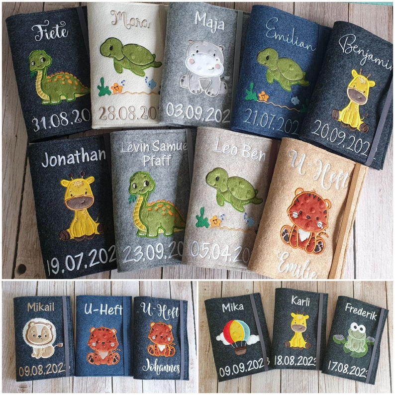 K&ouml;nnte beinhalten: Eine Sammlung personalisierter Filz-Buchh&uuml;llen. Jede H&uuml;lle zeigt ein gesticktes Tierdesign, wie einen Dinosaurier, eine Giraffe oder ein Nilpferd, zusammen mit einem Namen und Datum. Die H&uuml;llen sind in verschiedenen Farben erh&auml;ltlich, darunter Grau, Blau und Beige.