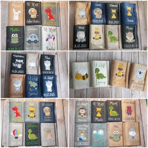 K&ouml;nnte beinhalten: Eine Sammlung personalisierter Filz-Buchh&uuml;llen mit gestickten Tierdesigns, Namen und Daten. Die H&uuml;llen zeigen verschiedene Tiere wie ein Kaninchen, einen L&ouml;wen, einen Dinosaurier, ein Nilpferd, einen Frosch, ein Auto, ein Einhorn und mehr.