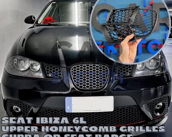 May include: Black SEAT Ibiza 6L car with a black honeycomb grille and a black CUPRA badge. The car has a black bumper and black headlights. The car is on a gray surface. #JoinTheFutureOfAutomotive
