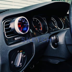 Könnte beinhalten: Autoinstrumententafel mit einem Turbomanometer und anderen Anzeigen. Das Turbomanometer hat ein weißes Zifferblatt mit blauen und roten Akzenten, das einen Wert von 0,8 anzeigt. Das Armaturenbrett ist schwarz mit silbernen Zierteilen.