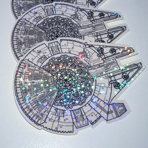 Könnte beinhalten: Ein Set mit sechs holografischen Aufklebern, die ein detailliertes Mandala-Design innerhalb der Umrisse des Raumschiffs Millennium Falcon zeigen.
