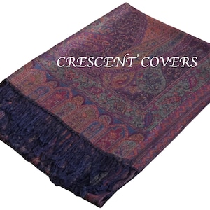 Op de afbeelding: Een sjaal met paisley-patroon in paars, rood en groen met een marineblauwe franje. De tekst "CRESCENT COVERS" wordt over het midden van de sjaal weergegeven. De sjaal is opgevouwen en wordt op een witte achtergrond getoond.