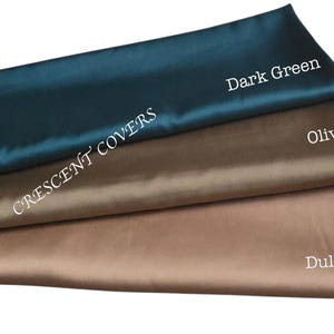 May include: Three folded fabric samples in dark green, olive, and dull gold. The top fabric is dark green, with the text "Dark Green" in white. The middle fabric is olive, and the bottom fabric is dull gold. The text "CRESCENT COVERS" is printed diagonally.