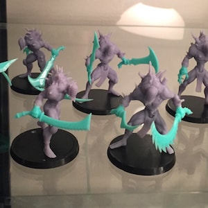 May include: A set of eight grey and teal miniature figures with swords. The figures are posed in a variety of fighting stances.