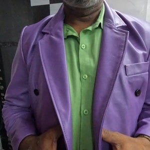 May include: A purple leather blazer with a double-breasted closure and a green button-down shirt underneath.
