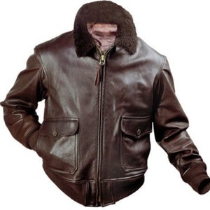May include: A brown leather bomber jacket with a shearling collar and zipper closure. The jacket has two flap pockets and ribbed cuffs.