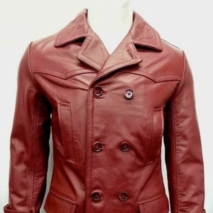 May include: A long, double-breasted burgundy leather coat with a notched collar and button closures.