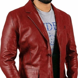 May include: A burgundy leather blazer with a three-button closure and a single pocket on the left side.