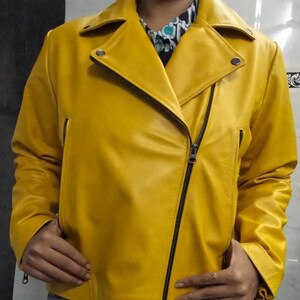 May include: A yellow leather motorcycle jacket with a zipper closure. The jacket has a collar and long sleeves.
