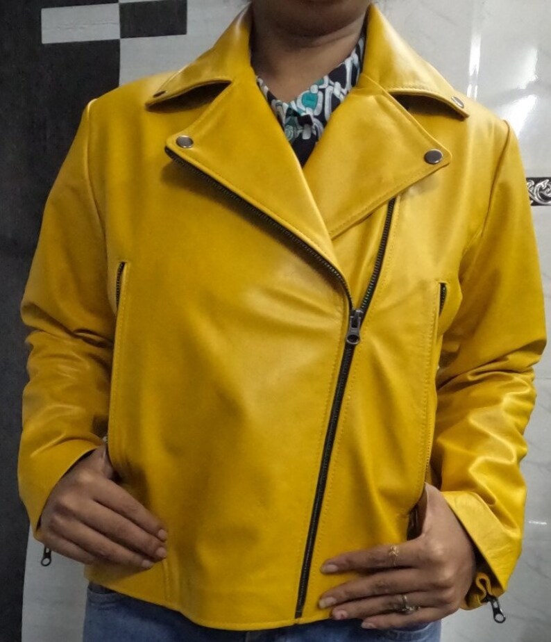 May include: A yellow leather motorcycle jacket with a zipper closure. The jacket has a collar and long sleeves.