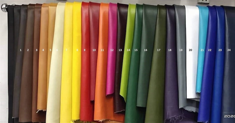 May include: A collection of 24 leather swatches in various colors, including black, brown, tan, yellow, red, orange, pink, green, blue, and white. The swatches are numbered 1 through 24.