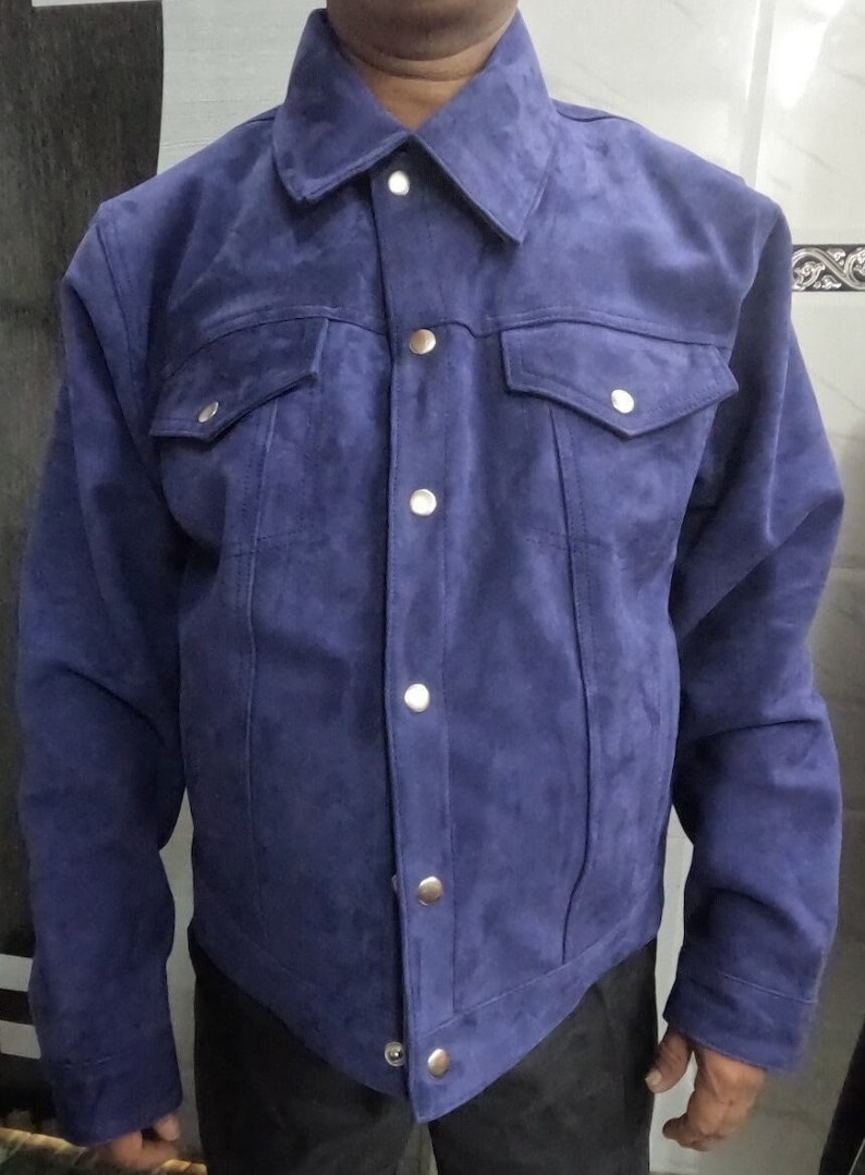 May include: A blue suede jacket with a button-up front and two flap pockets. The jacket has a classic denim style.