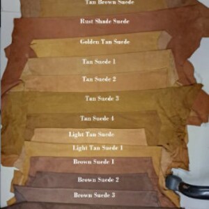 May include: A variety of suede leather swatches in different shades of brown, tan, and blue. The swatches are labeled with their color and type, such as "Royal Blue Suede", "Tan Brown Suede", and "Light Tan Suede".
