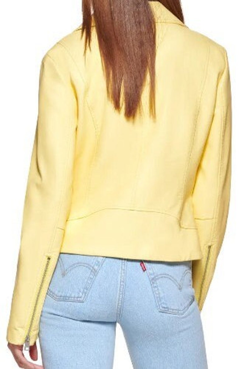May include: A bright yellow leather jacket with a zipper closure. The jacket has a cropped fit and is worn over light blue jeans.