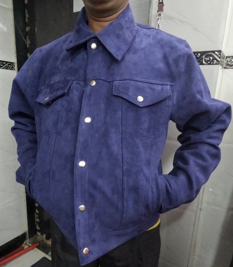 May include: A blue suede jacket with a button-up front and two flap pockets.