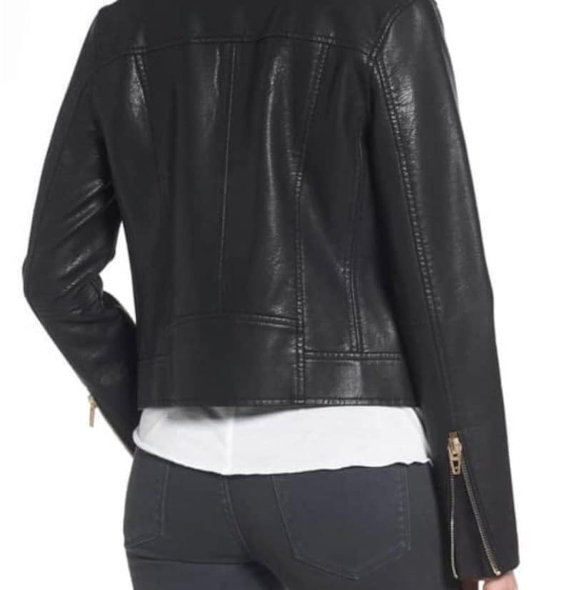 May include: Black faux leather moto jacket with zipper details. The jacket has a cropped fit and a stand-up collar.