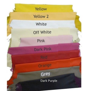 May include: A stack of fabric swatches in various colors, including yellow, white, pink, red, orange, grey, and dark purple. The swatches are labeled with their corresponding colors.