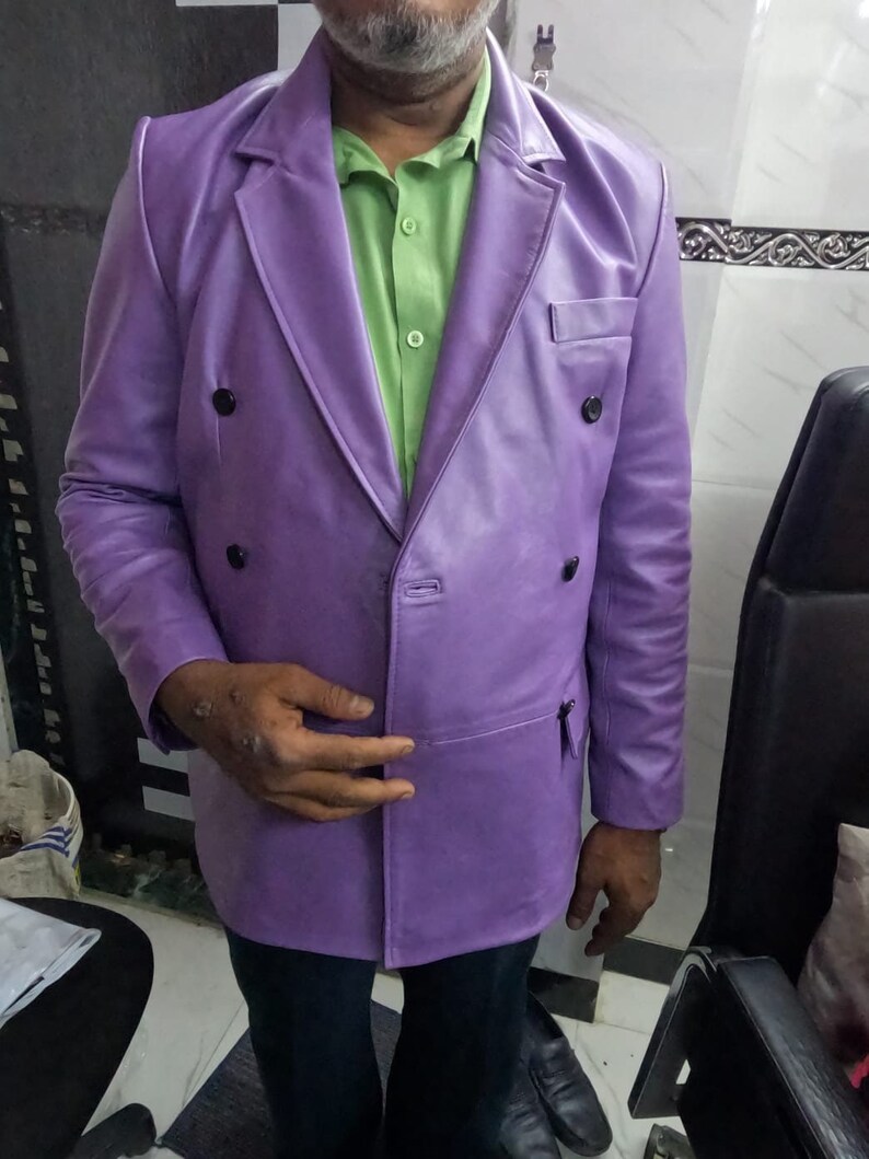 May include: A purple leather double-breasted blazer with a green button-down shirt underneath.