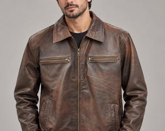 Può includere: Una giacca in pelle marrone con finitura vissuta, caratterizzata da un colletto classico, una chiusura frontale con zip, due tasche orizzontali con zip sul petto, due tasche laterali e un orlo elasticizzato in vita.