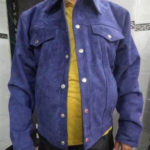 May include: A blue suede jacket with a button-up front and two flap pockets. The jacket has a classic denim style.