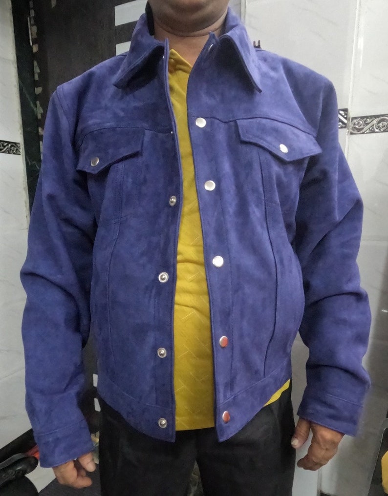 May include: A blue suede jacket with a button-up front and two flap pockets. The jacket has a classic denim style.