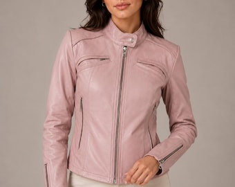 May include: A dusty rose leather jacket featuring a mandarin collar with a snap button closure, a full-length front zipper, two zippered chest pockets, two lower zippered side pockets, and zippered cuffs, paired with light beige pants.