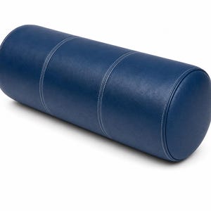 May include: A cylindrical bolster pillow in a deep navy blue color. The pillow features a smooth, leather-like texture and is constructed with three distinct sections joined by visible white double-stitched seams along the length and ends.
