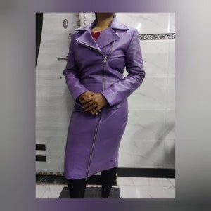 May include: A long purple leather jacket with a zip closure. The jacket has a collar and long sleeves.