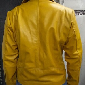 May include: A yellow leather jacket with a zipper closure. The jacket has a stand-up collar and long sleeves.