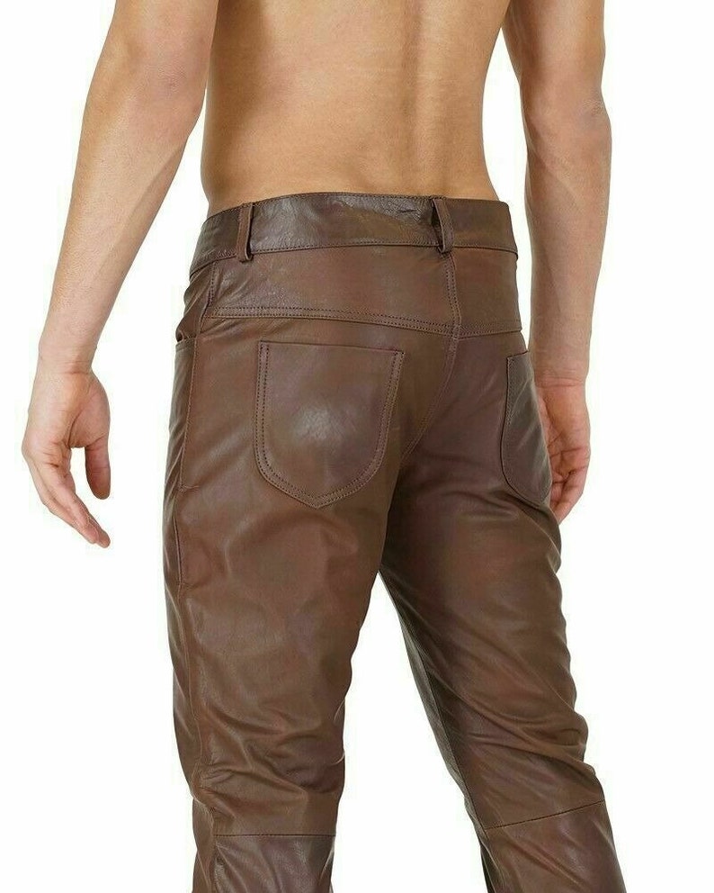 May include: Brown leather pants with a slim fit. The pants have a five-pocket design and a zipper fly.