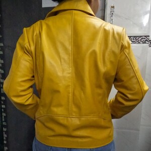 May include: A yellow leather jacket with a zipper closure. The jacket has a stand-up collar and long sleeves.