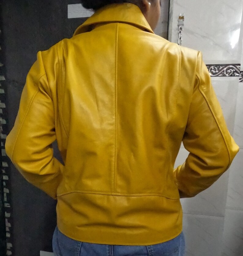 May include: A yellow leather jacket with a zipper closure. The jacket has a stand-up collar and long sleeves.