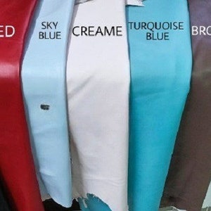 May include: A selection of leather swatches in various colors, including black, red, sky blue, cream, turquoise blue, brown, white, and dark brown.