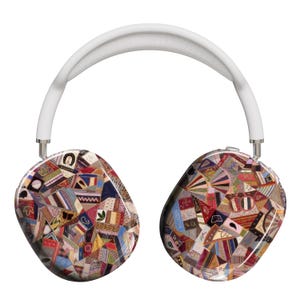 Può includere: Cuffie wireless bianche con un motivo a patchwork colorato sui padiglioni auricolari. Il motivo è composto da diversi tessuti in tonalità di rosso, blu, verde, giallo e marrone.