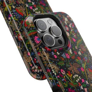 Op de afbeelding: Een zwarte telefoonhoes met een bloemenpatroon. De hoes heeft een verhoogde camerabult met drie lenzen.